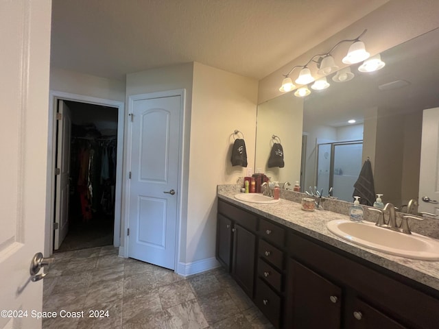 bathroom with vanity and a shower with door