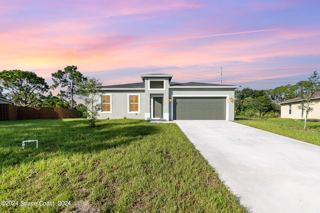 view of front of home featuring a yard and a garage