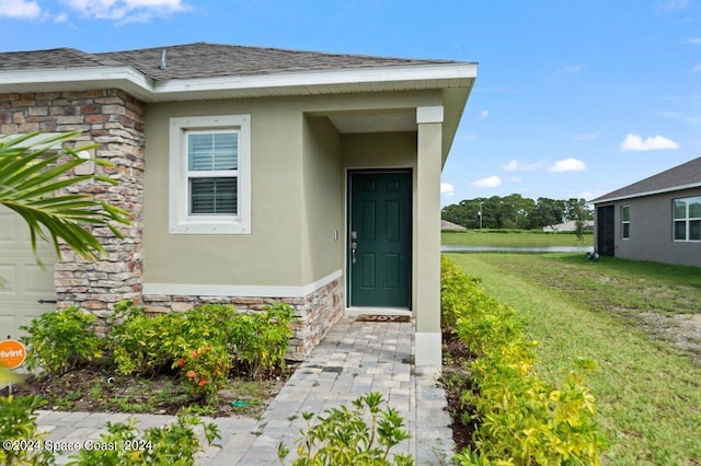 entrance to property with a lawn