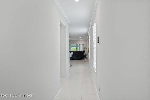 hallway with light tile patterned floors and crown molding