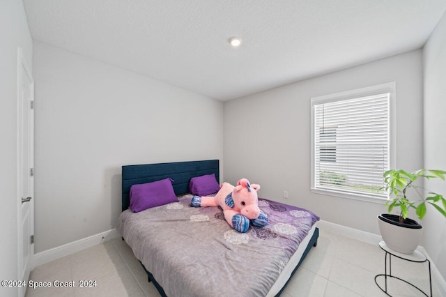 bedroom with a textured ceiling and light tile patterned flooring