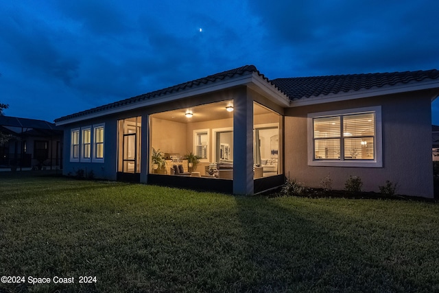 rear view of property featuring a lawn