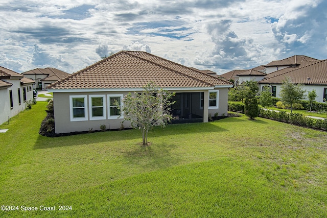 rear view of house featuring a lawn