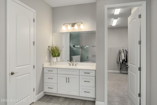 bathroom featuring walk in shower and vanity