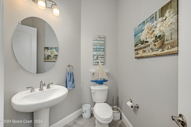 bathroom featuring wood-type flooring and toilet