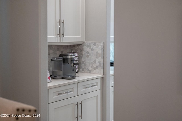 interior space with tasteful backsplash and white cabinetry