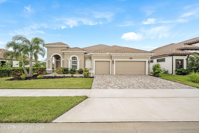 mediterranean / spanish-style house with a front lawn and a garage