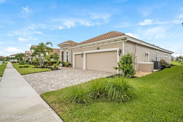 view of home's exterior with a garage, cooling unit, and a lawn