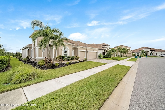 mediterranean / spanish house featuring a garage and a front yard