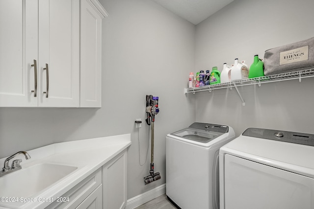 laundry room featuring independent washer and dryer, sink, and cabinets