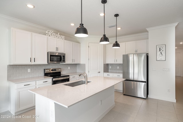 kitchen with pendant lighting, appliances with stainless steel finishes, white cabinetry, sink, and a center island with sink