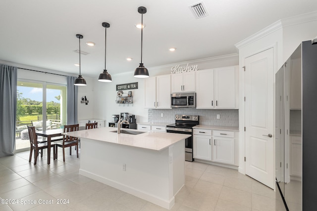 kitchen featuring decorative light fixtures, sink, white cabinetry, a kitchen island with sink, and appliances with stainless steel finishes