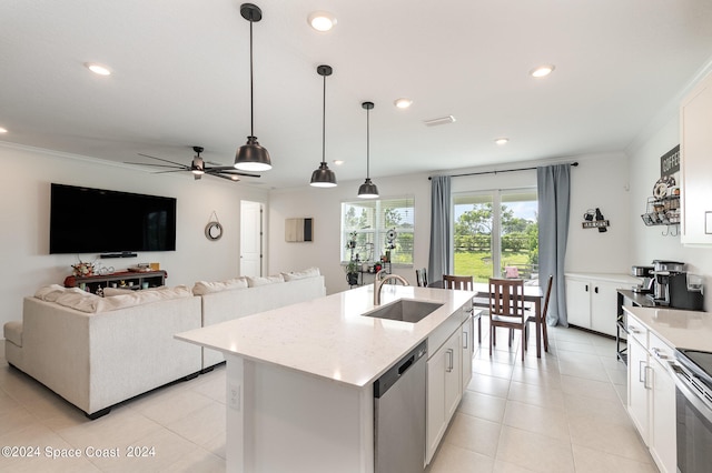 kitchen with pendant lighting, appliances with stainless steel finishes, white cabinetry, sink, and a kitchen island with sink