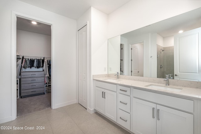 bathroom with walk in shower, vanity, and tile patterned floors