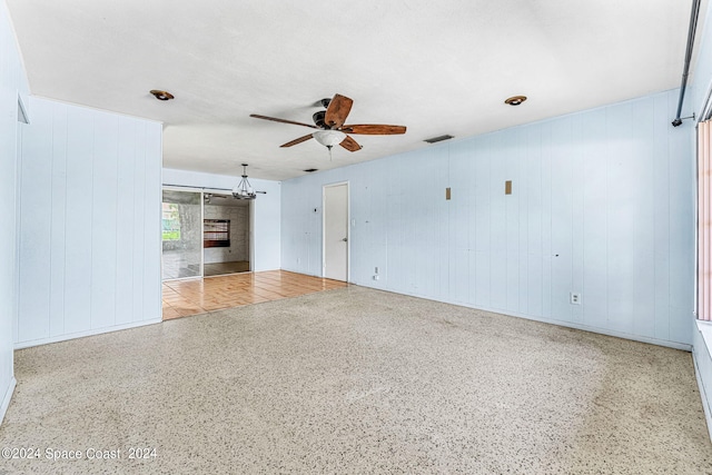 spare room featuring a fireplace and ceiling fan