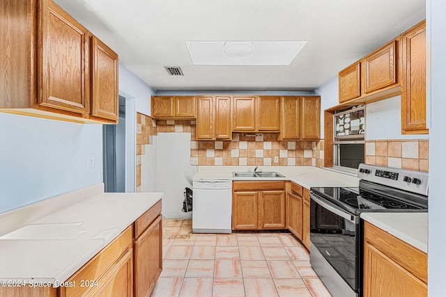 kitchen with white dishwasher, electric stove, light tile patterned floors, and backsplash