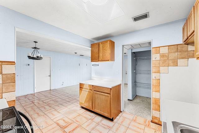 kitchen featuring pendant lighting and wooden walls