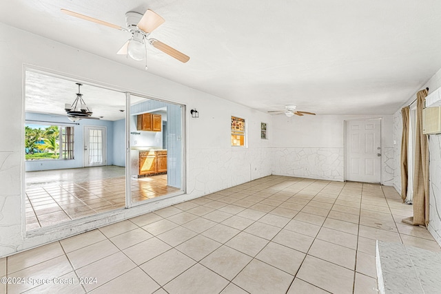 unfurnished room with light tile patterned floors and ceiling fan