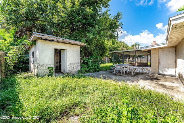 view of yard with a storage shed and a patio area