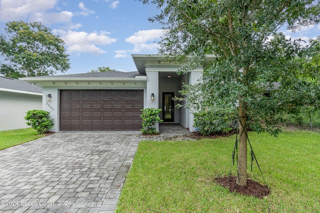 view of front of property with a front lawn and a garage