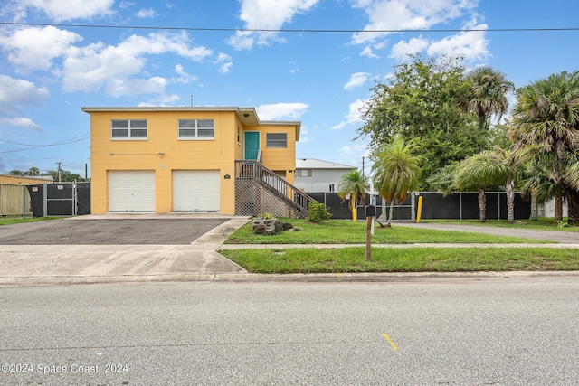 view of front of home with a garage and a front lawn