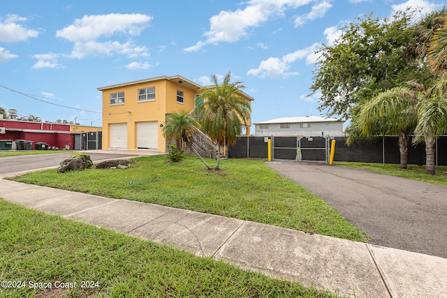 view of front of property with a garage and a front lawn