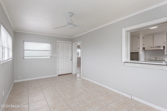 tiled spare room featuring plenty of natural light, ceiling fan, and ornamental molding