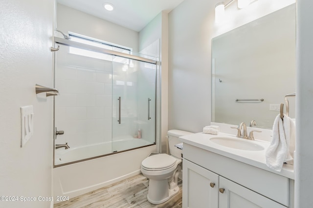 7356 Millbrook Ave, Melbourne, FL 32940 - full bath with toilet, wood finished floors, vanity, and shower / bath combination with glass door
