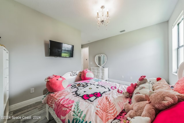 7356 Millbrook Ave, Melbourne, FL 32940 - bedroom featuring wood finished floors, visible vents, baseboards, and a notable chandelier