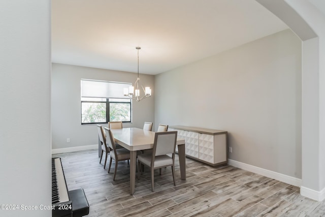 7356 Millbrook Ave, Melbourne, FL 32940 - dining area with arched walkways, baseboards, an inviting chandelier, and wood finished floors