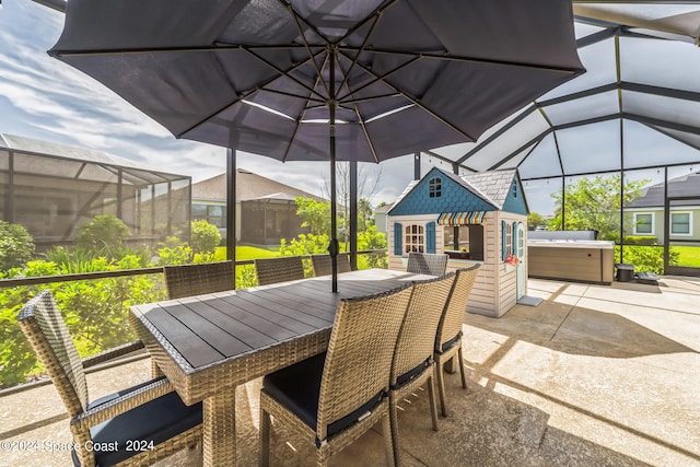 view of patio / terrace featuring glass enclosure, a hot tub, and an outdoor structure