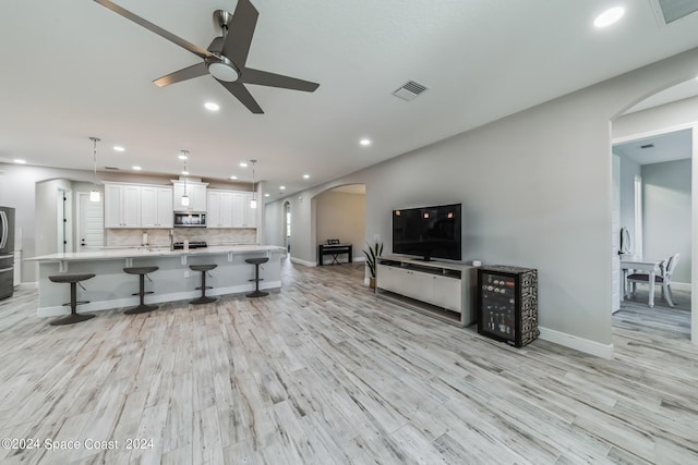 7356 Millbrook Ave, Melbourne, FL 32940 - living room featuring visible vents, recessed lighting, light wood finished floors, ceiling fan, and arched walkways