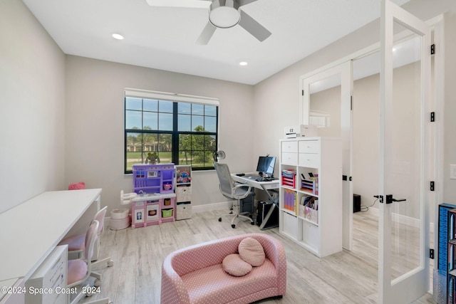 home office with light hardwood / wood-style flooring and ceiling fan