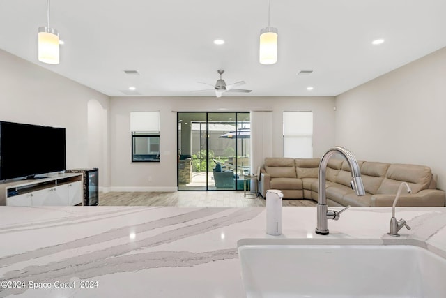 living room with ceiling fan, sink, and light hardwood / wood-style flooring