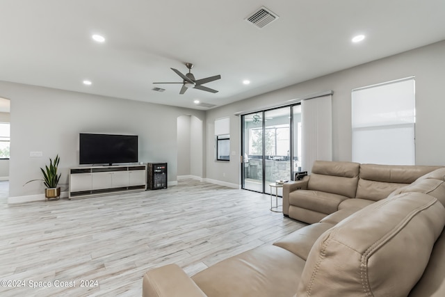 living room with ceiling fan and light hardwood / wood-style flooring