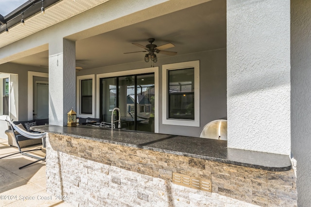 view of patio with ceiling fan and a wet bar