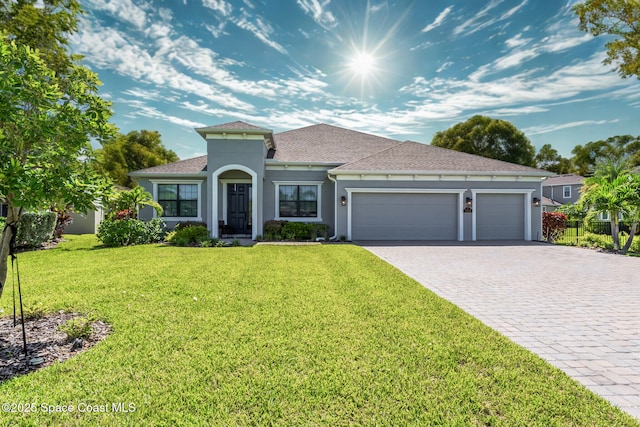 7356 Millbrook Ave, Melbourne, FL 32940 - mediterranean / spanish home with roof with shingles, an attached garage, stucco siding, a front lawn, and decorative driveway