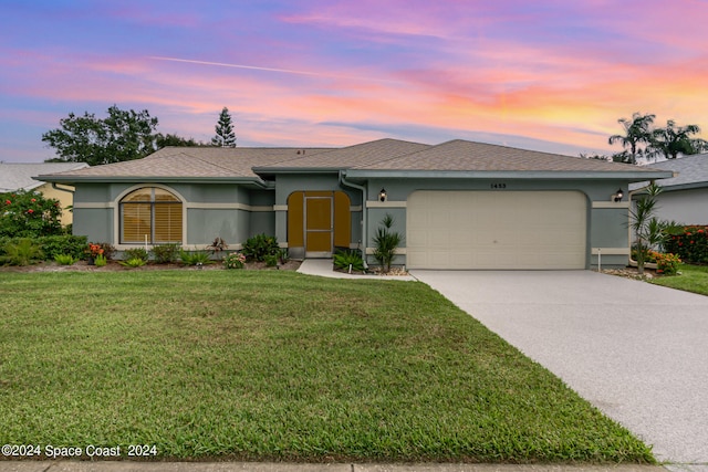 single story home with a garage and a yard