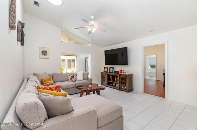 living room with ceiling fan, lofted ceiling, and light tile patterned floors