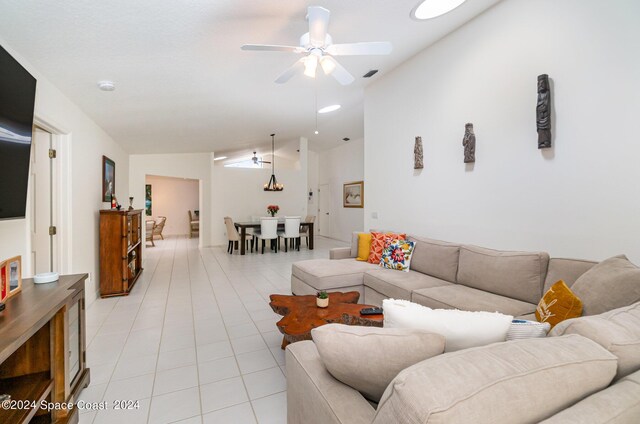 tiled living room featuring vaulted ceiling and ceiling fan