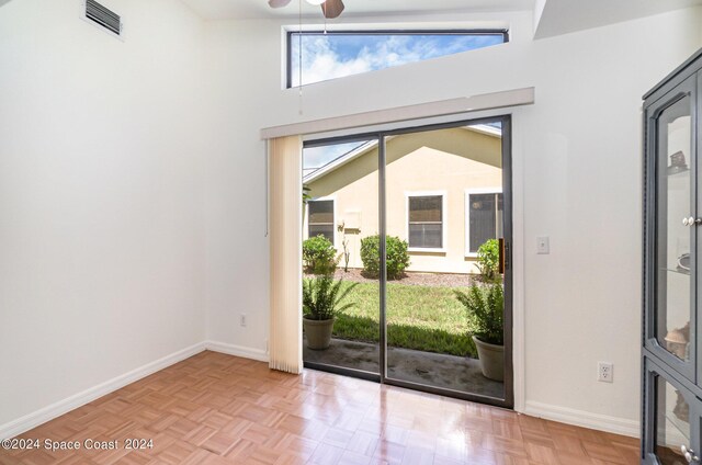 doorway featuring light parquet flooring, lofted ceiling, and ceiling fan