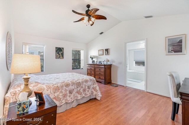 bedroom featuring connected bathroom, vaulted ceiling, light hardwood / wood-style floors, and ceiling fan