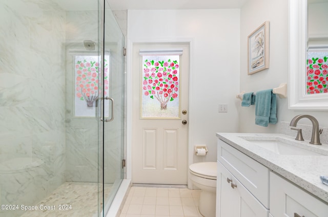 bathroom with tile patterned flooring, vanity, an enclosed shower, and toilet