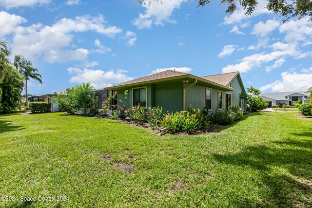 view of property exterior featuring a lanai and a lawn