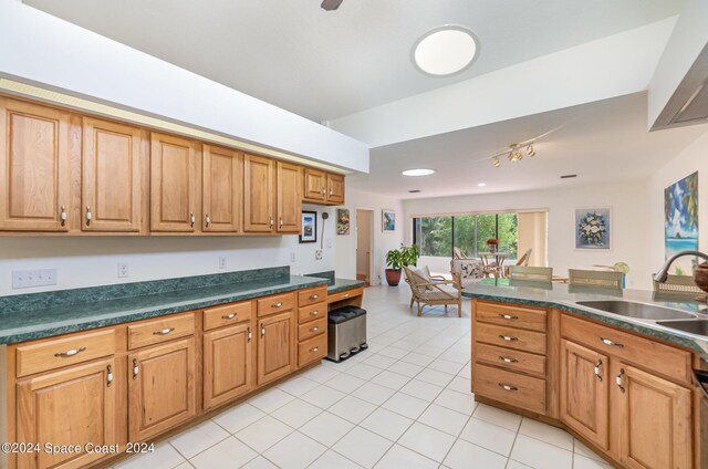 kitchen featuring light tile patterned flooring, dishwasher, and sink