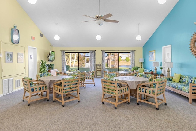 carpeted dining room with high vaulted ceiling and ceiling fan