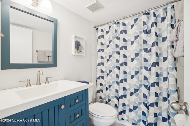 bathroom with vanity, curtained shower, and toilet