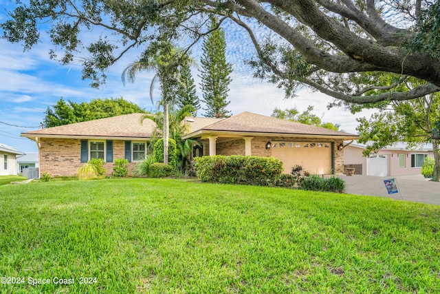 ranch-style home with central AC unit, a front yard, and a garage