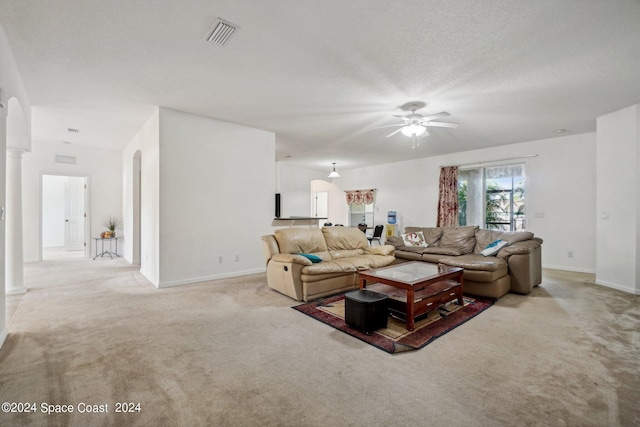 carpeted living room with ceiling fan and a textured ceiling