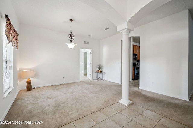 carpeted empty room with plenty of natural light and ornate columns